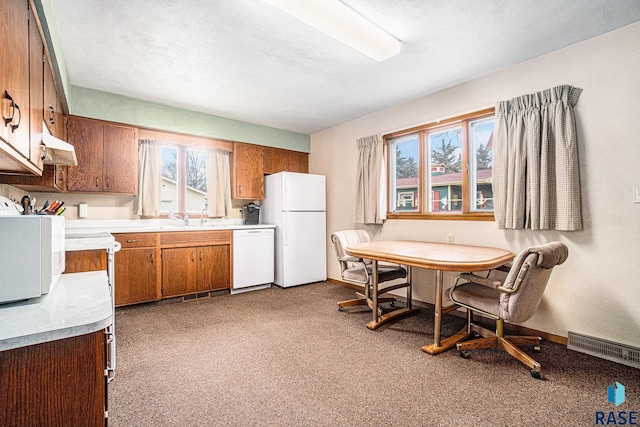 kitchen featuring visible vents, light countertops, brown cabinets, white appliances, and a sink