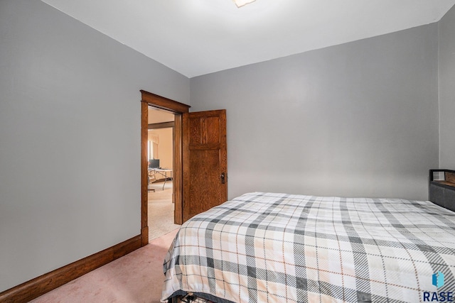 bedroom featuring baseboards and light carpet