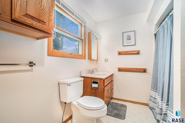 full bathroom featuring toilet, vanity, and baseboards