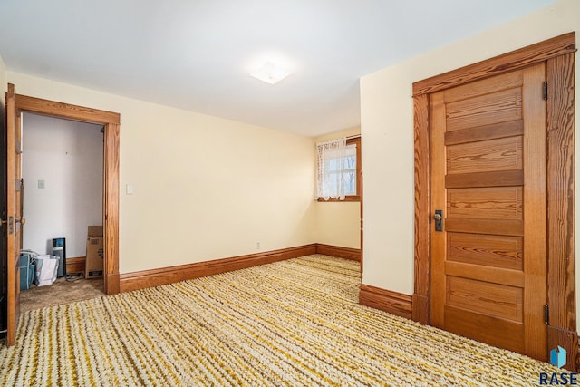 unfurnished room with carpet flooring and baseboards