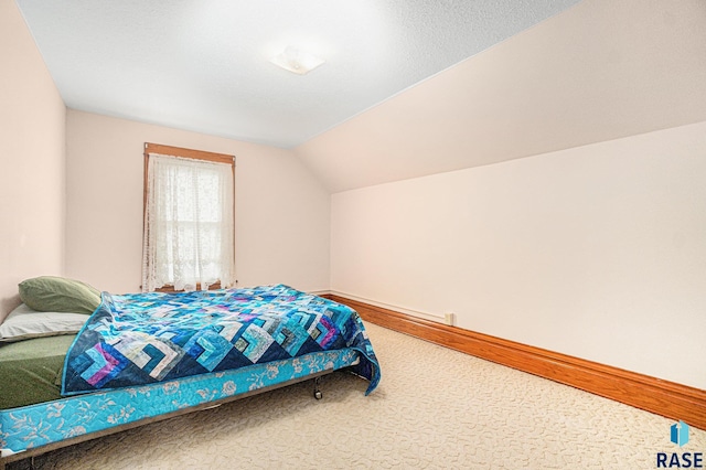 bedroom with lofted ceiling, carpet, and baseboards