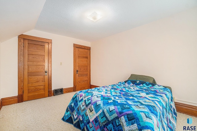 bedroom featuring baseboards, a textured ceiling, lofted ceiling, and carpet floors