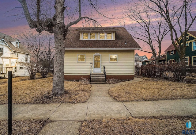 bungalow featuring roof with shingles