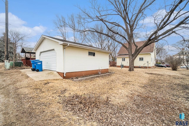 view of side of property featuring driveway and an outdoor structure