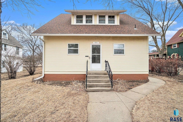 bungalow-style home featuring roof with shingles and entry steps