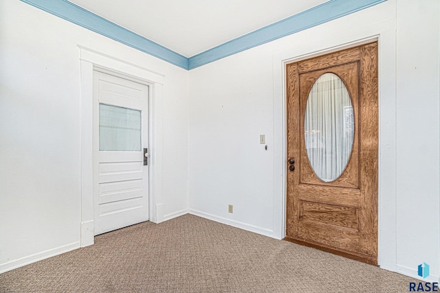 carpeted entryway featuring baseboards