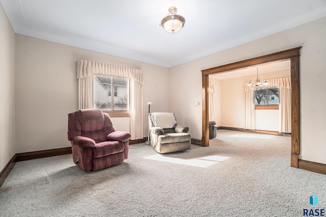 sitting room featuring baseboards, carpet floors, an inviting chandelier, and crown molding