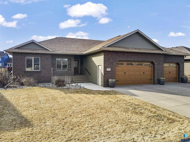 single story home with a porch, concrete driveway, a front yard, a garage, and brick siding