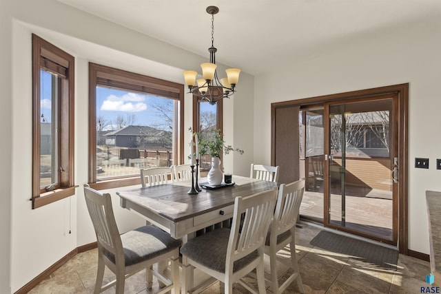 dining room with baseboards, plenty of natural light, and a chandelier