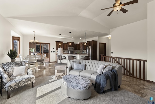 living room with lofted ceiling, ceiling fan with notable chandelier, and stone finish flooring