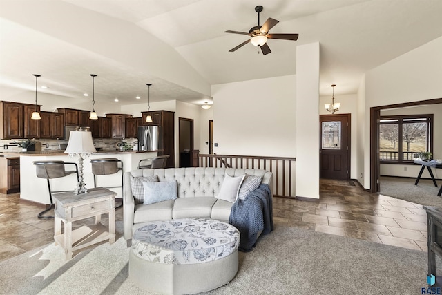 living room with stone tile flooring, ceiling fan with notable chandelier, baseboards, and lofted ceiling