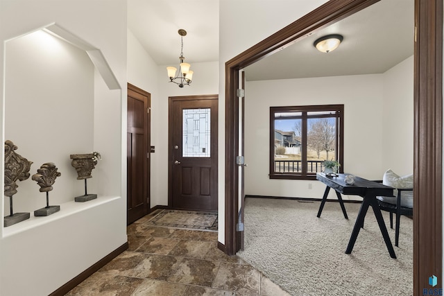 foyer entrance with an inviting chandelier and baseboards