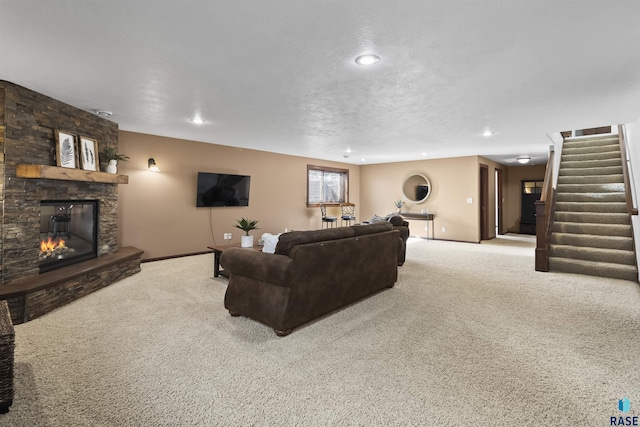 living room featuring stairs, a stone fireplace, carpet floors, and a textured ceiling