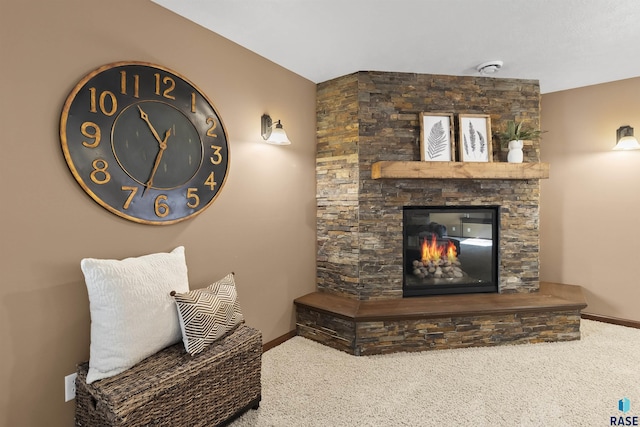 living area with a fireplace, carpet, and baseboards