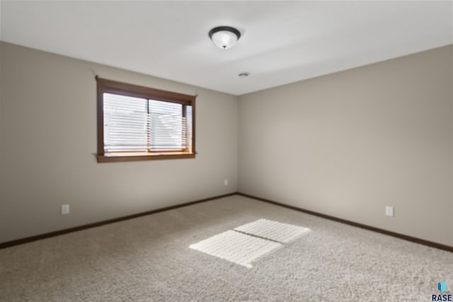 carpeted empty room with baseboards