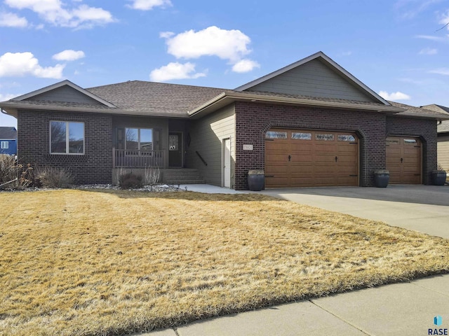 single story home featuring brick siding, an attached garage, driveway, and a front yard