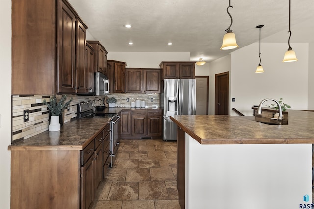 kitchen with stone finish flooring, tasteful backsplash, dark countertops, and appliances with stainless steel finishes