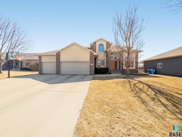 view of front facade with stucco siding, concrete driveway, a front lawn, a garage, and brick siding