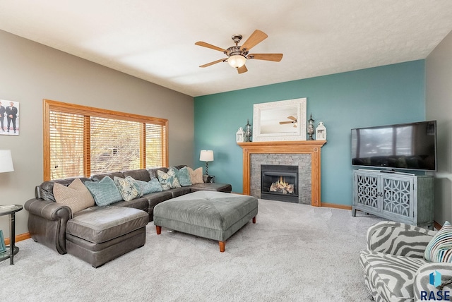 carpeted living area featuring baseboards, a ceiling fan, and a tile fireplace