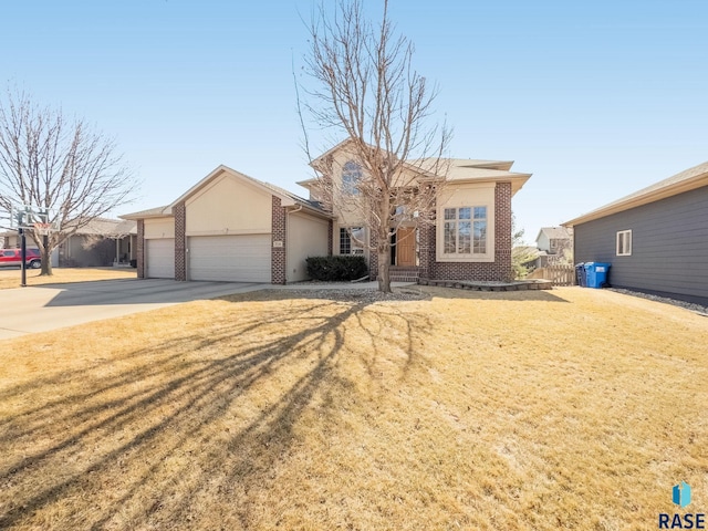 view of front facade with a front lawn, driveway, fence, a garage, and brick siding