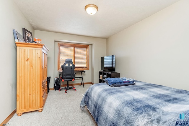 bedroom with light colored carpet and baseboards