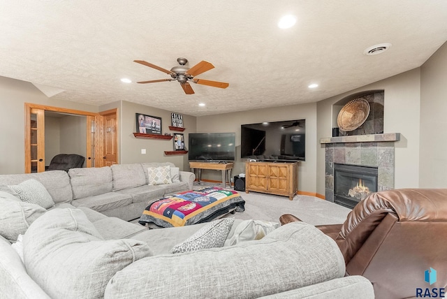 living room with visible vents, a textured ceiling, recessed lighting, carpet flooring, and a fireplace