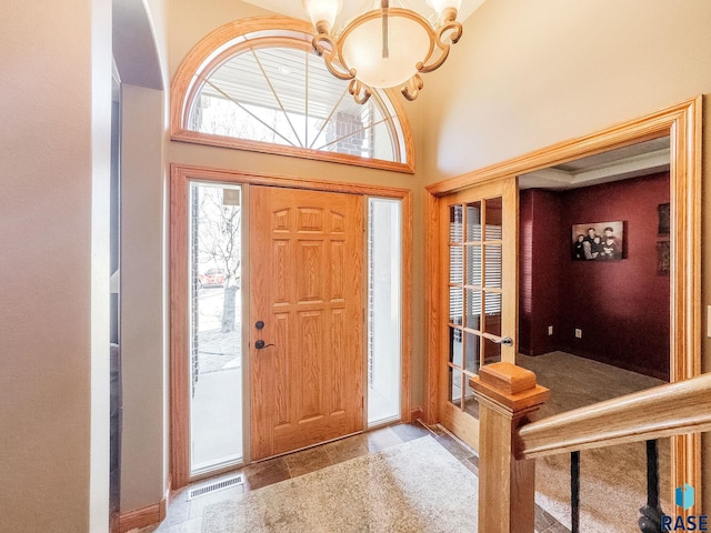 entrance foyer featuring a high ceiling, visible vents, and a chandelier