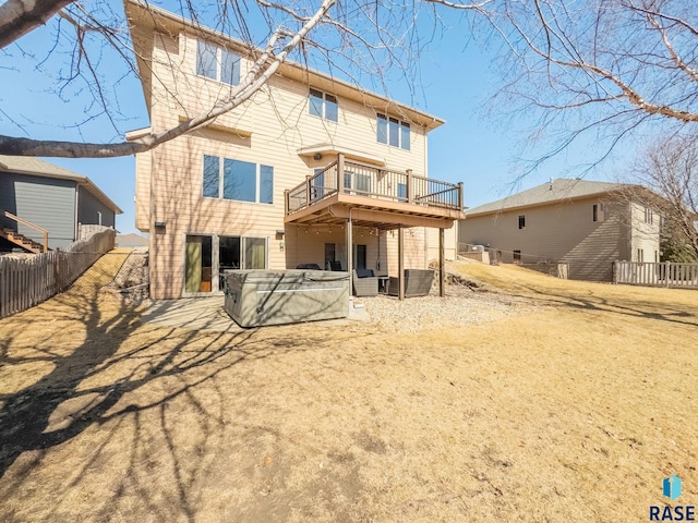 rear view of house featuring cooling unit, fence, a hot tub, a deck, and a patio area