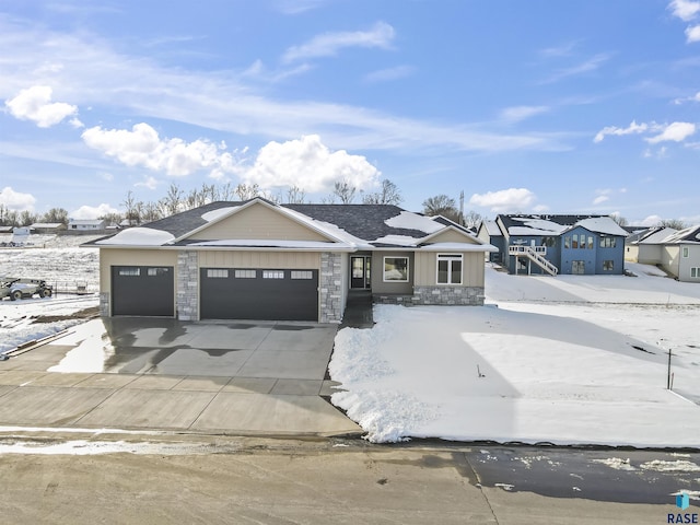 single story home with concrete driveway, an attached garage, and stone siding