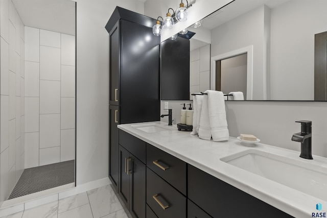 full bathroom featuring a sink, tiled shower, marble finish floor, and double vanity