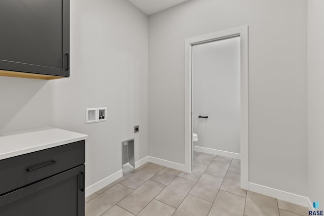 laundry room with baseboards, washer hookup, light tile patterned flooring, cabinet space, and electric dryer hookup