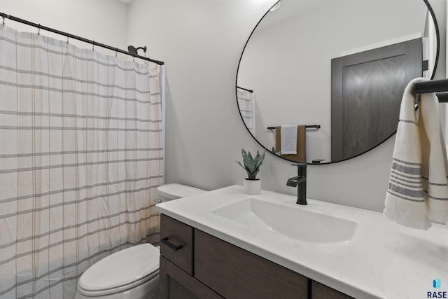 bathroom with curtained shower, toilet, and vanity