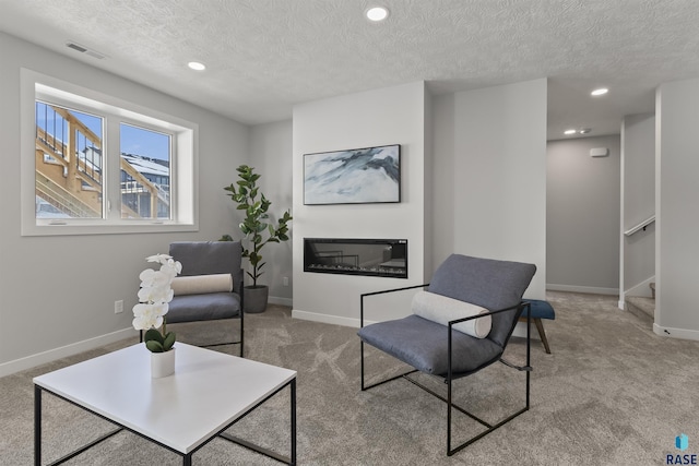 sitting room with stairs, carpet, visible vents, and baseboards