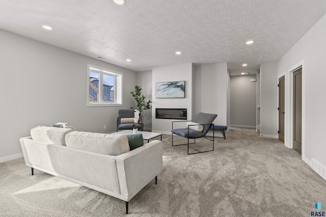 carpeted living room featuring a glass covered fireplace, recessed lighting, a textured ceiling, and baseboards