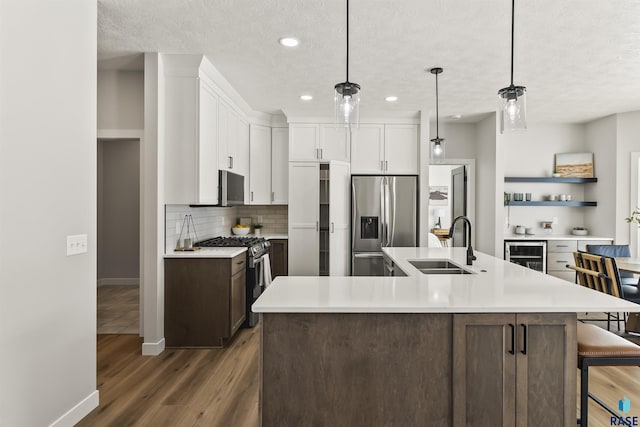 kitchen featuring light countertops, tasteful backsplash, appliances with stainless steel finishes, and a sink