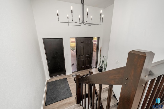 entryway featuring a chandelier, a high ceiling, and light wood-style flooring