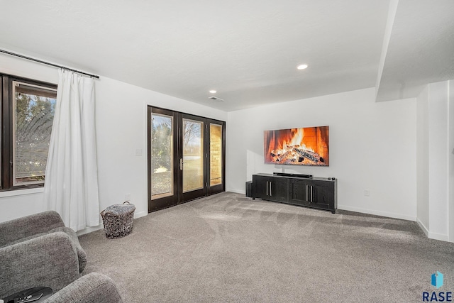 carpeted living area featuring visible vents, french doors, baseboards, and a wealth of natural light