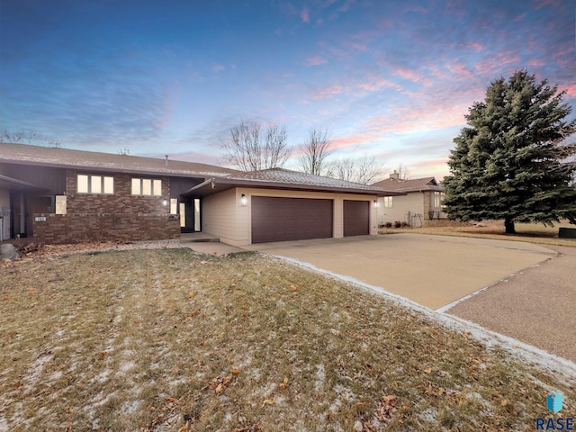 ranch-style house with concrete driveway, an attached garage, and brick siding