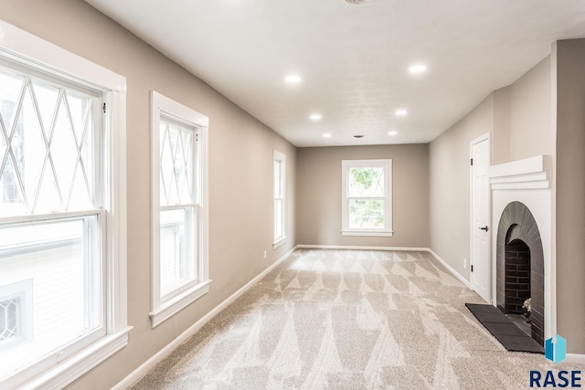 unfurnished living room with recessed lighting, light colored carpet, and baseboards