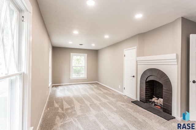 unfurnished living room with recessed lighting, baseboards, carpet floors, and a fireplace