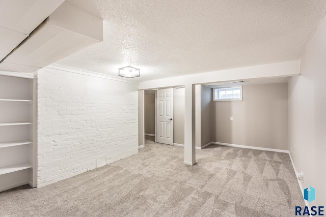 basement featuring baseboards, brick wall, a textured ceiling, and carpet