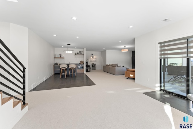 carpeted dining area with stairway, recessed lighting, bar area, and visible vents