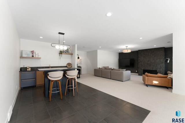 dining space with recessed lighting, dark carpet, wet bar, and a large fireplace