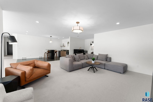 carpeted living area with recessed lighting and visible vents