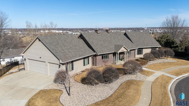 view of front of home featuring fence, concrete driveway, an attached garage, a shingled roof, and brick siding