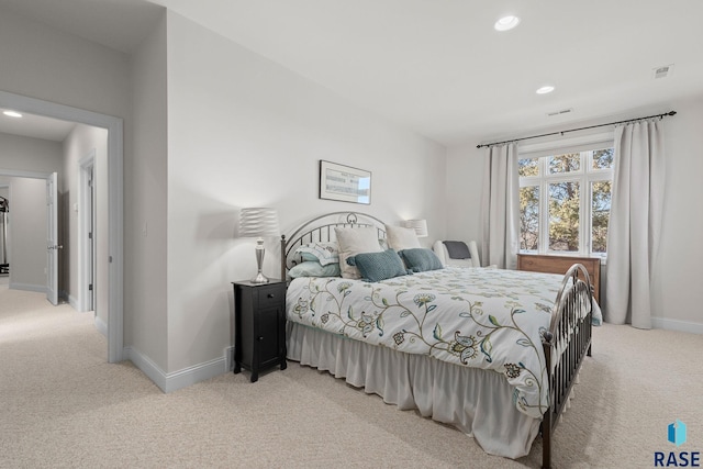 bedroom featuring visible vents, baseboards, and light carpet