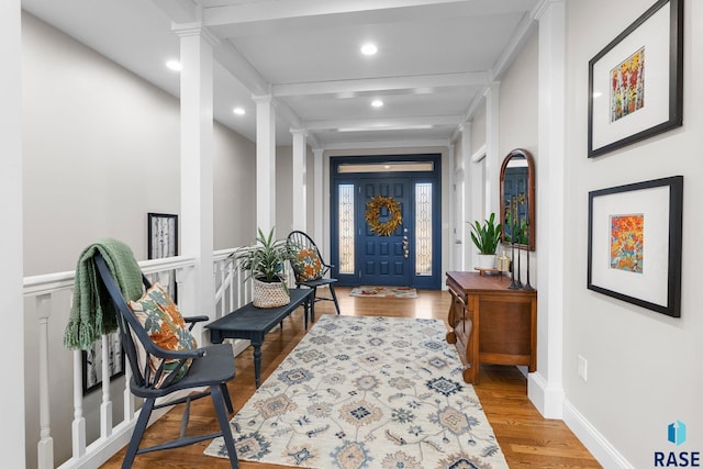 entrance foyer with baseboards, beamed ceiling, recessed lighting, wood finished floors, and ornate columns