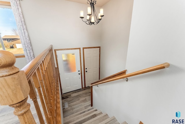 stairway featuring a chandelier, visible vents, and wood finished floors