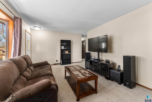 living area featuring light colored carpet, baseboards, and a textured ceiling