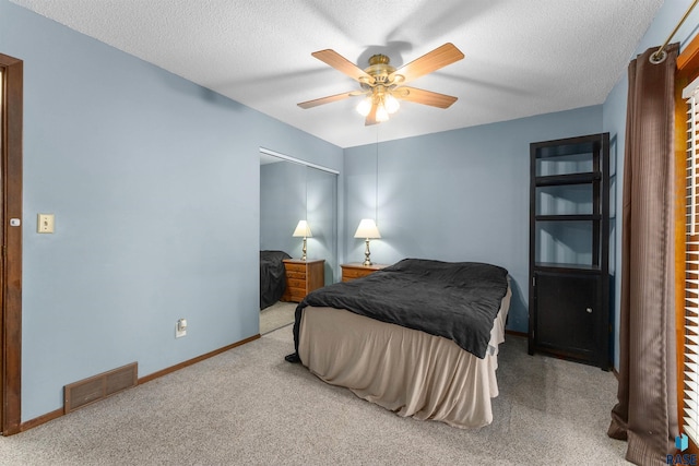 carpeted bedroom featuring visible vents, ceiling fan, a textured ceiling, and baseboards